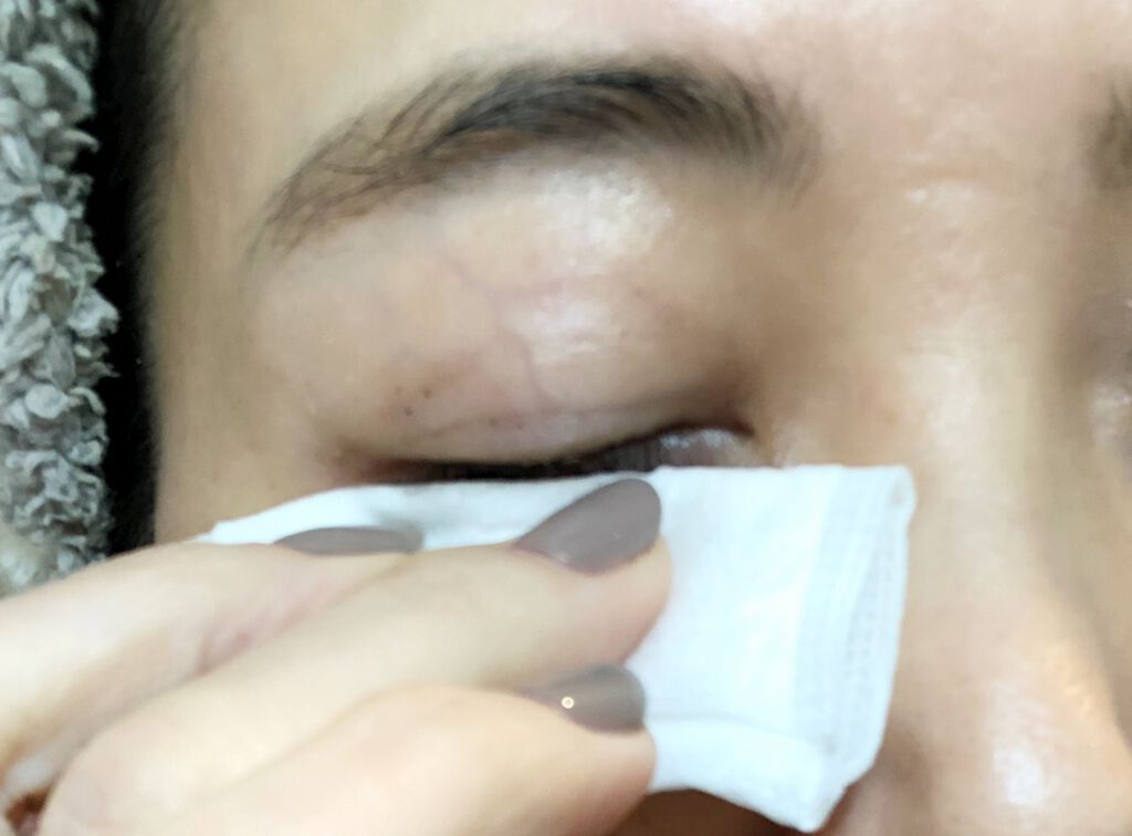 まつ毛をコットンで拭き取る様子