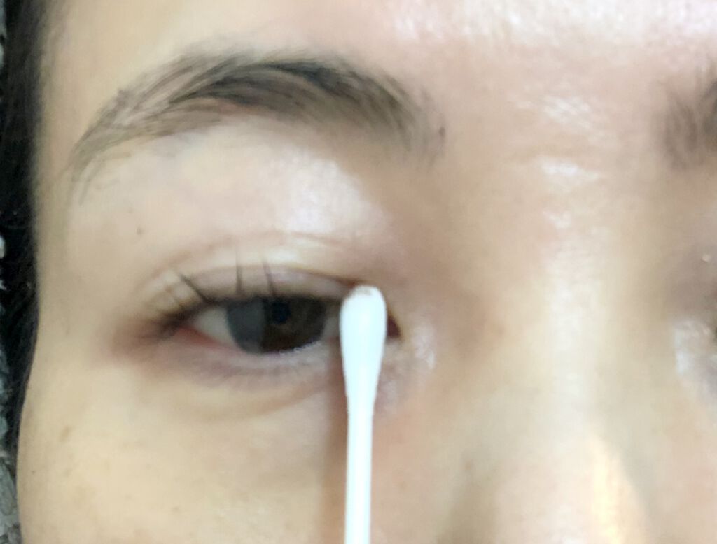 綿棒でまつ毛を拭く様子