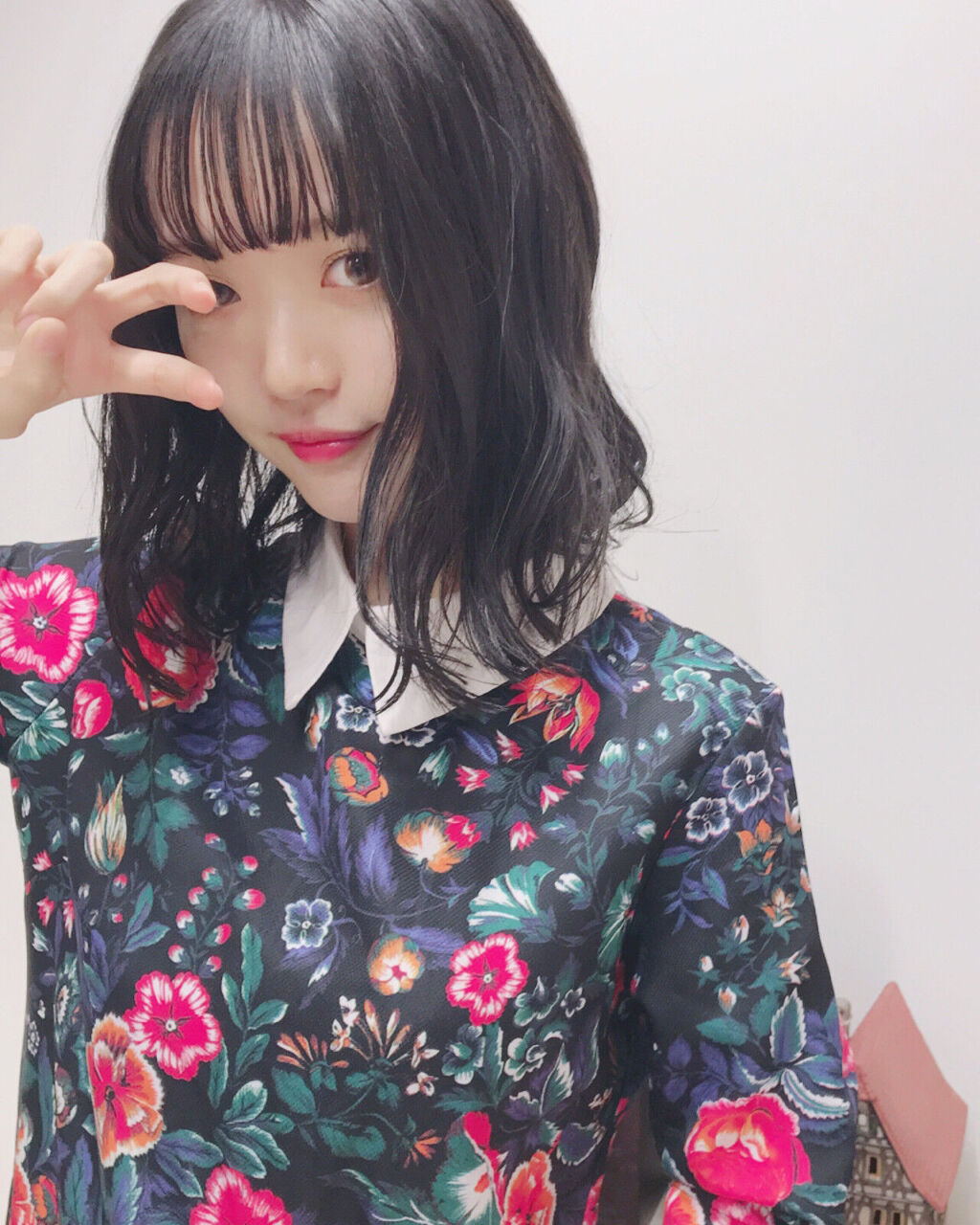 顔の横でピースサインをする女性