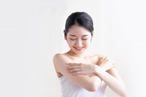 腕を撫でる女性