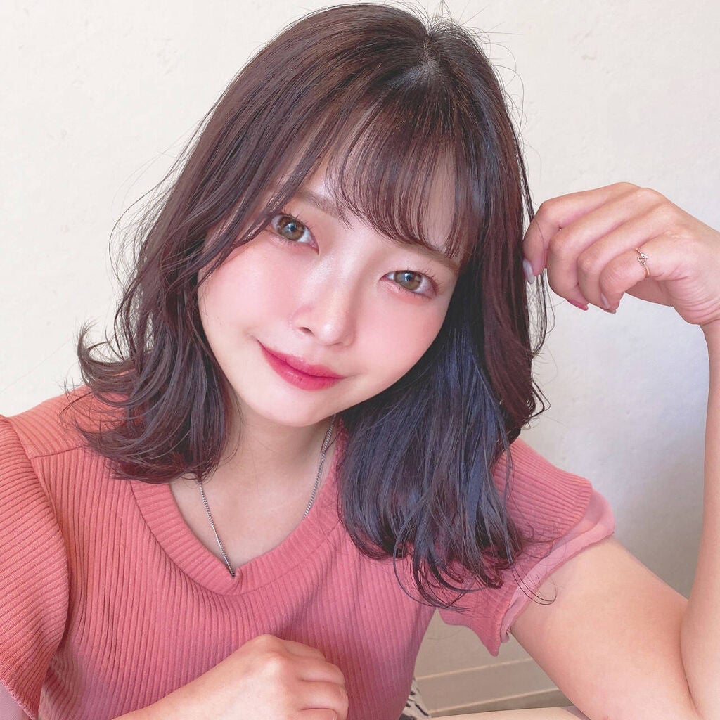 頬の高い位置に濃いめにチークを取り入れた女性