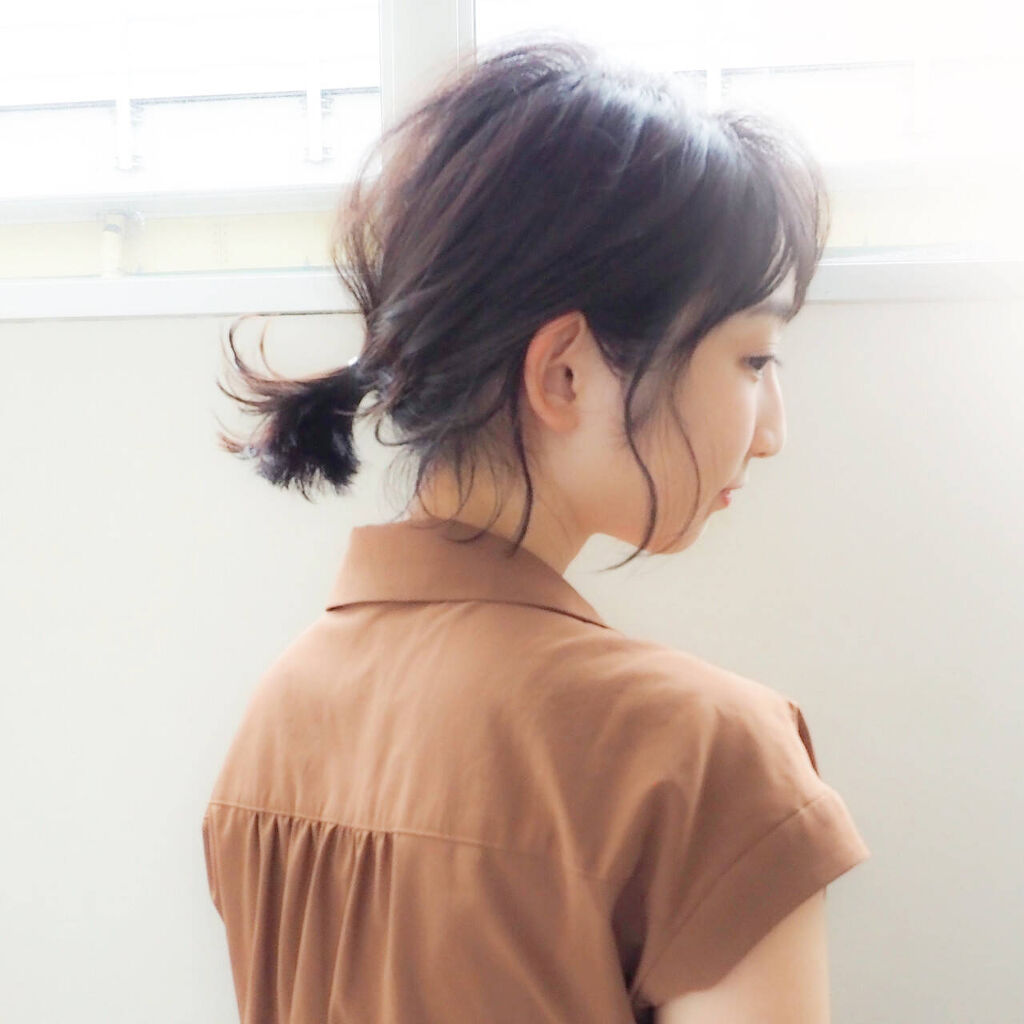 一つ結びをしているボブヘアの女性