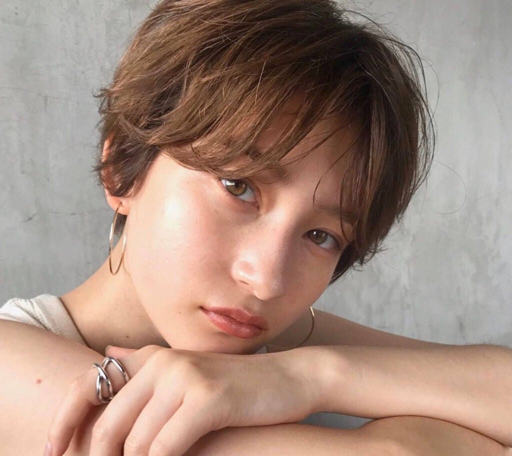 目の下の前髪を横に流したショートヘアの女性