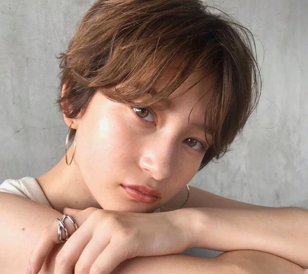目の下の前髪を横に流したショートヘアの女性