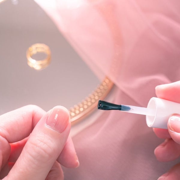 ネイルオイルを爪に塗っている