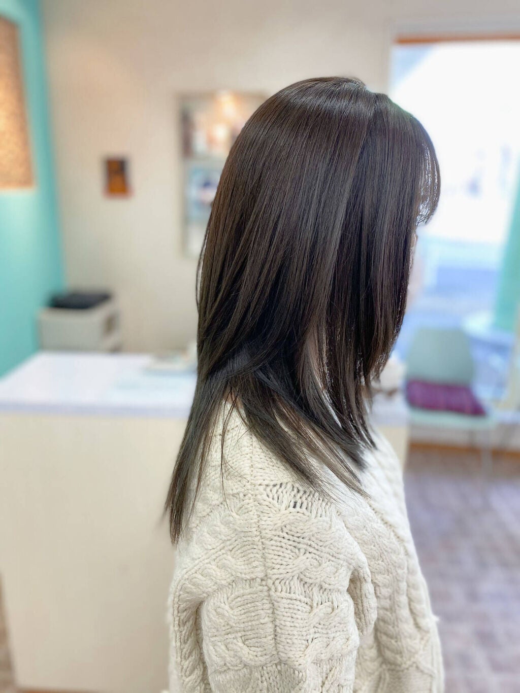 暗めアッシュグレーのロングヘアをした女性の横顔