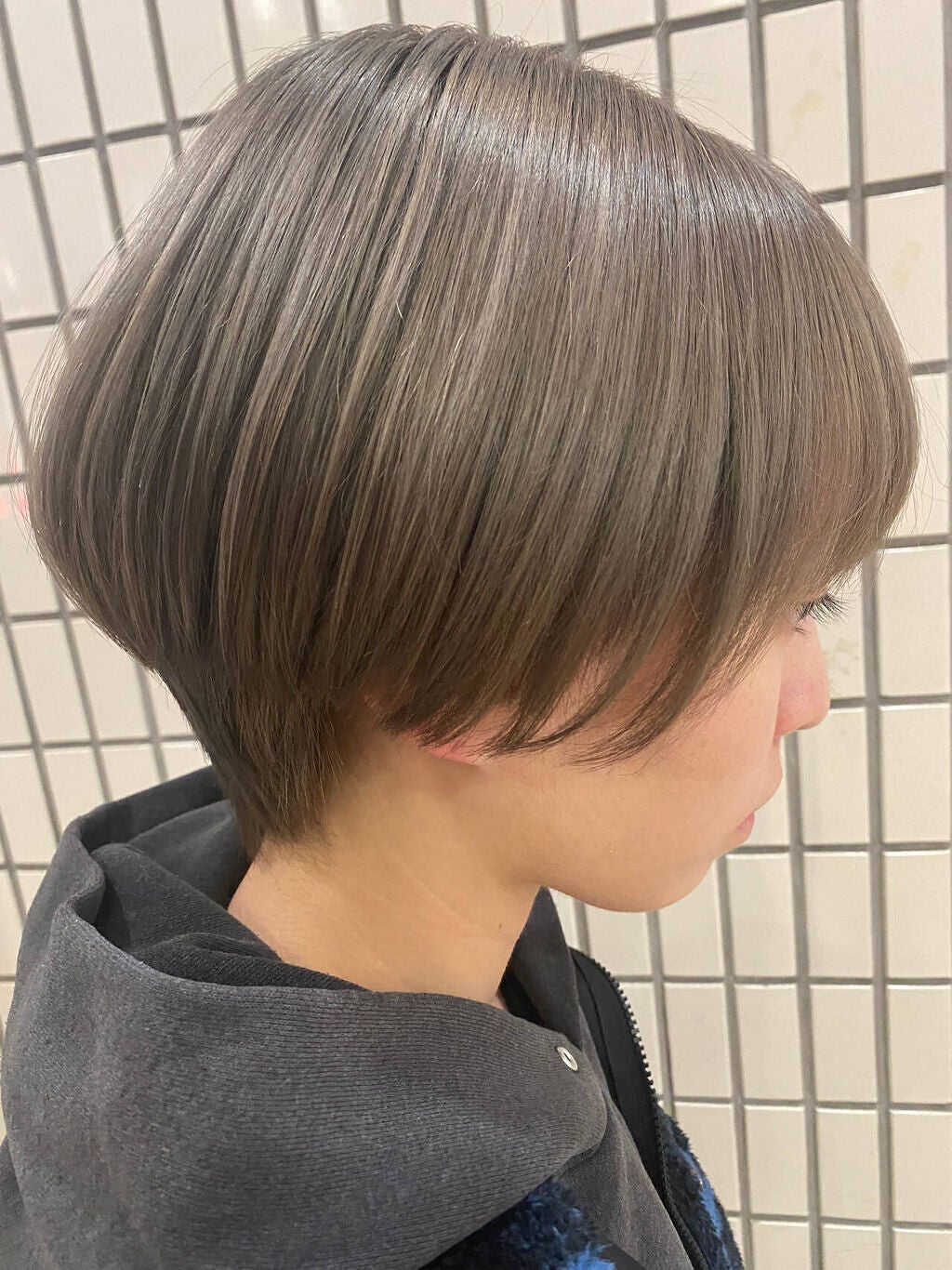アッシュグレーのショートヘアの女性の横顔