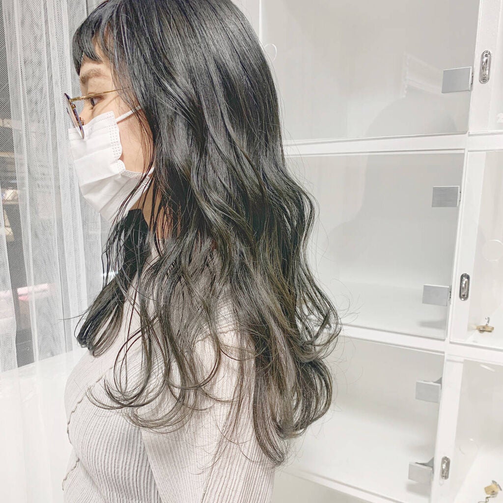 アッシュグリーンカラーのロングウェーブヘアスタイルの女性