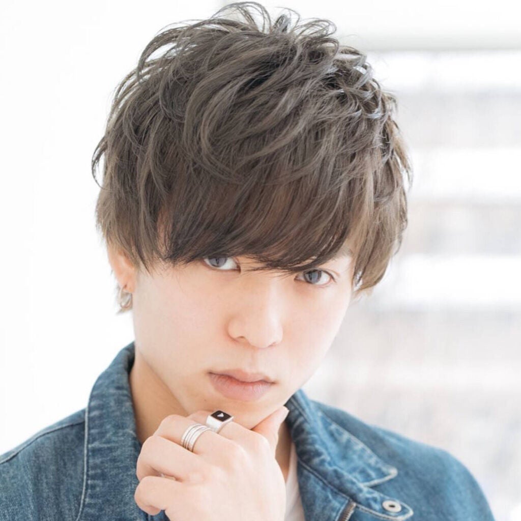 暗めアッシュグリーンを取り入れた厚めバングヘアの男性