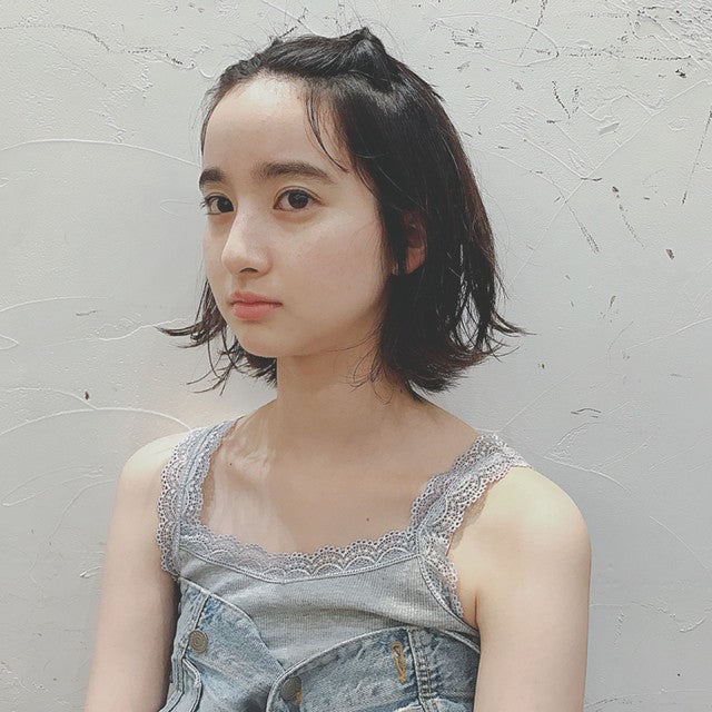 前髪を上げたボブヘアの女性