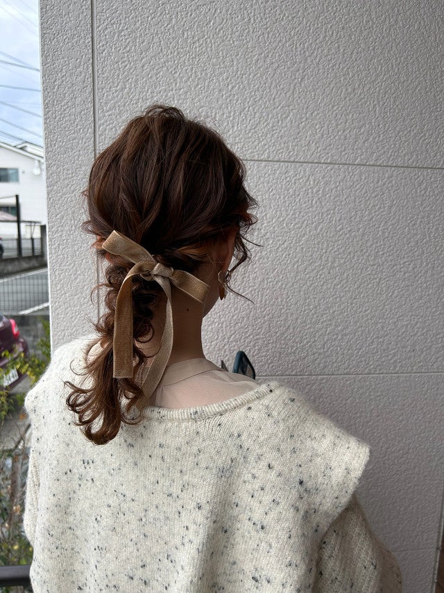 リボンをつけたポニーテール姿の女性