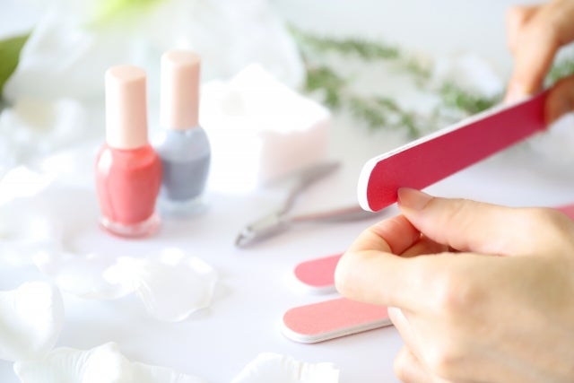 爪ヤスリをしている手とネイル用品