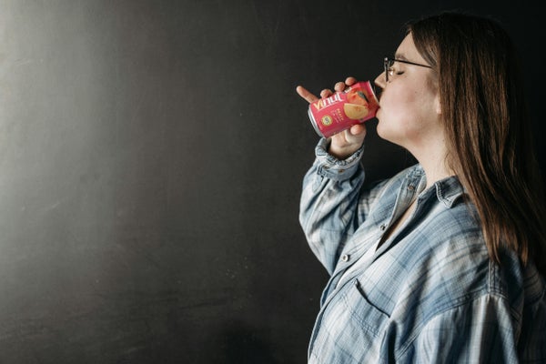 女性が缶のドリンクを飲んでいる