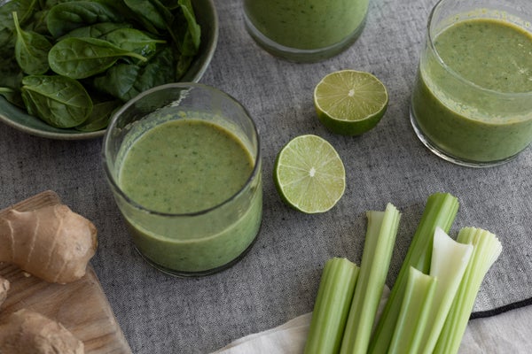 グラスに入ったグリーンスムージーと野菜類