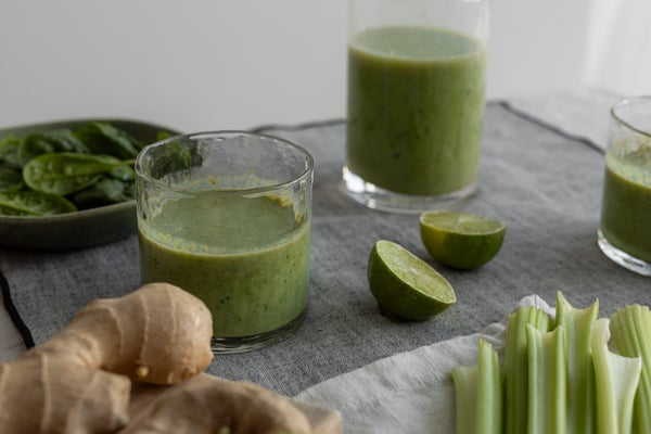 グラスに入ったグリーンスムージーと野菜