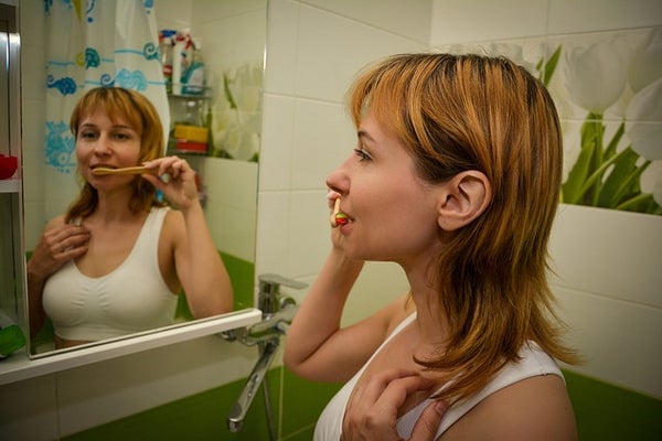 鏡の前で歯磨きする女性