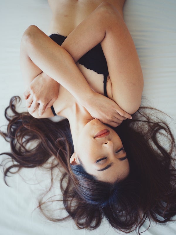 胸を支えて寝る女性