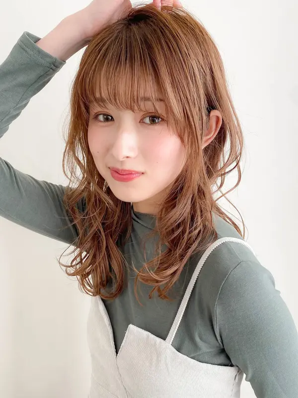 髪をかきあげるツヤ肌の女性