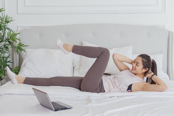 ベッドの上でトレーニングをしている女性