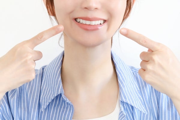 口角を指さす女性