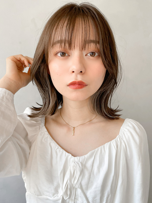 20代の髪に触れる女性