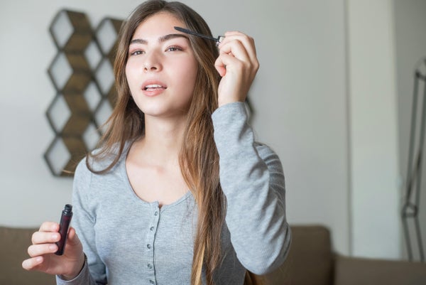 マスカラを塗るロングヘアの女性