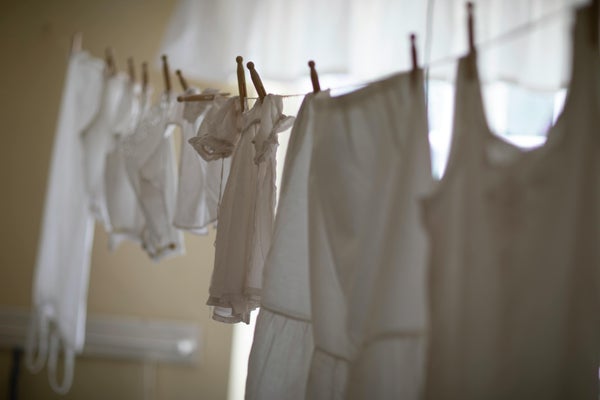 室内に紐を張り複数の衣類が干されている様子