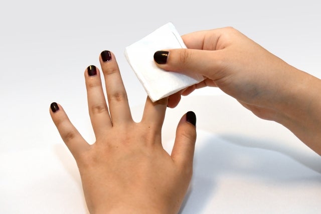 ジェルネイルを拭き取っている手