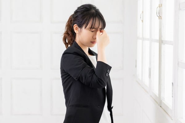 目を押さえている女性