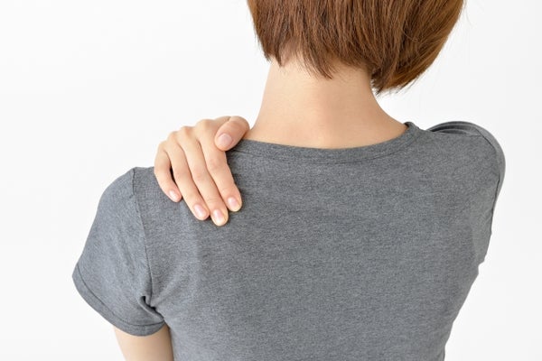 肩を押さえている女性の後ろ姿