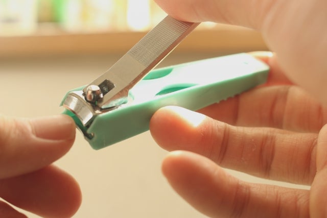 爪切りで爪を切っている手