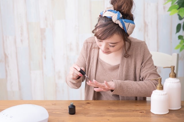 セルフでジェルネイルをする女性