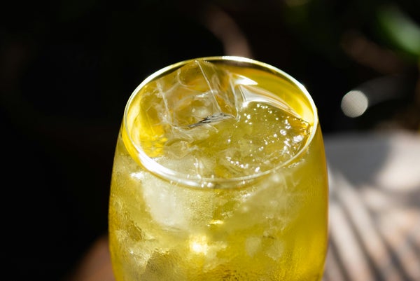 グラスに注がれた黄色い飲み物と氷