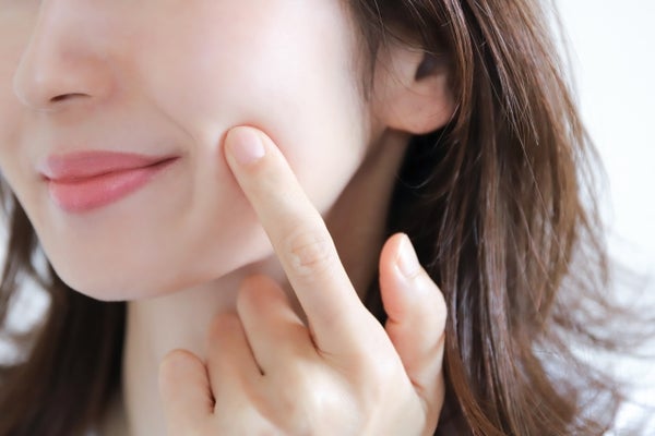 ほっぺたを触っている女性