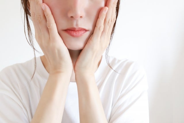 両手で頬を押さえている女性