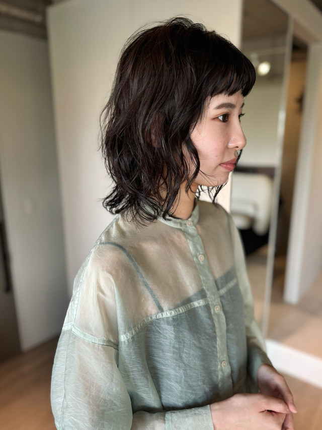 透け感のあるトップスを着る女性