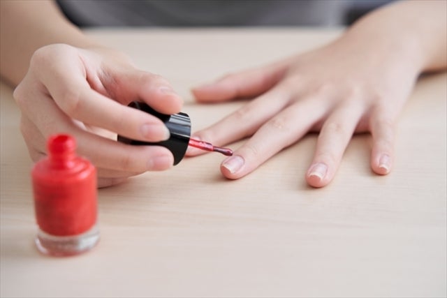 マニキュアを塗っている子供の手