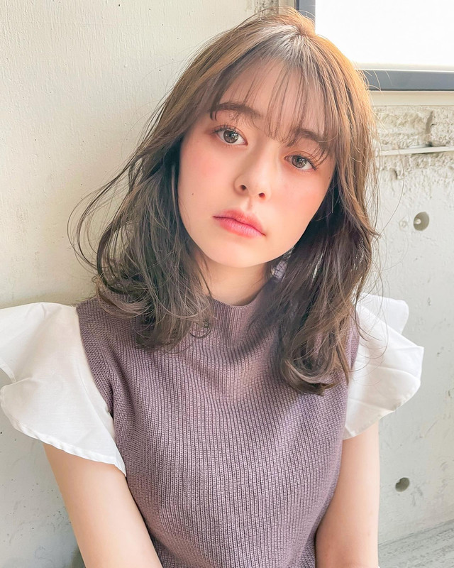 ゆるいカーブがかかったミディアムヘアの女性