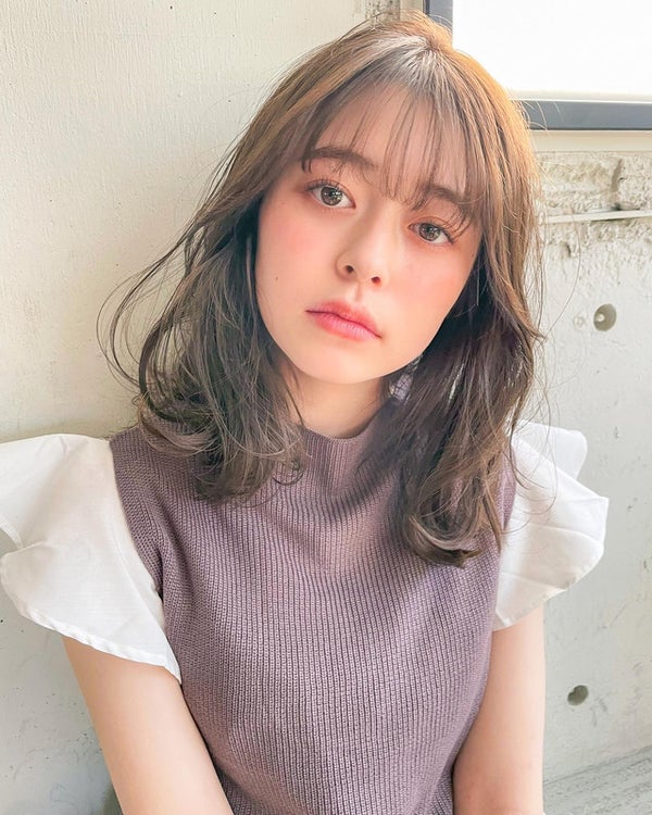 ゆるいカーブがかかったミディアムヘアの女性