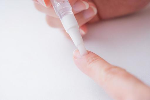 ネイルオイルを塗る指先の画像