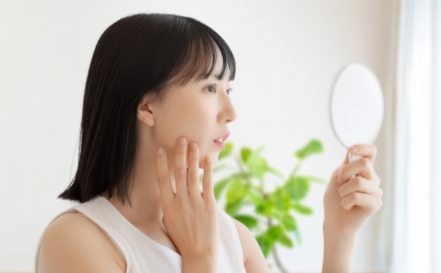 鏡で顔を見る女性
