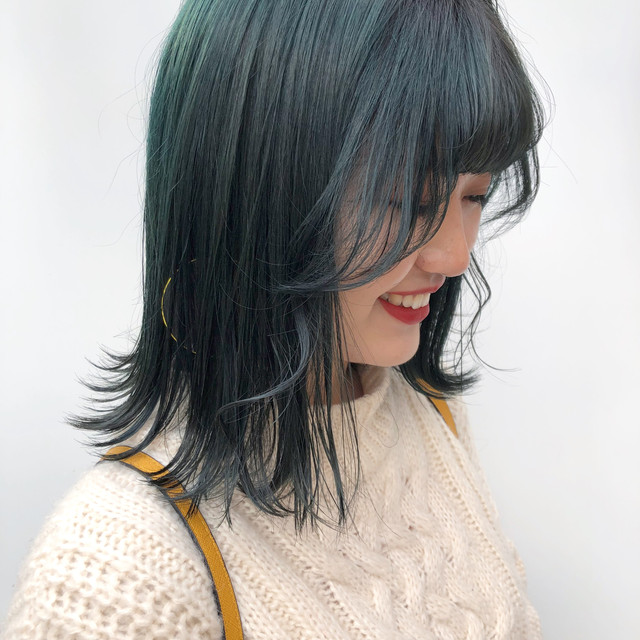 アッシュグリーンにカラーリングされた韓国風ミディアムスタイルの女性