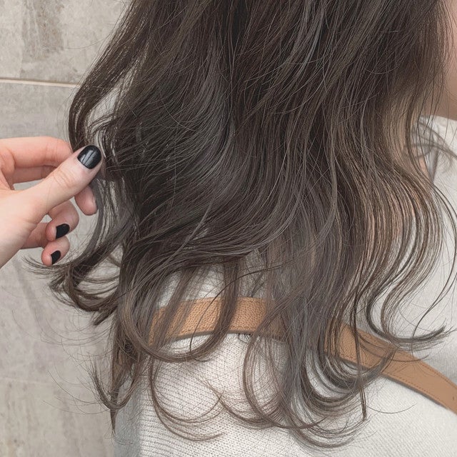 アッシュグリーンカラーのウェーブがかかった毛先