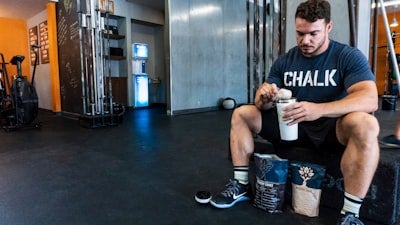 ジムでプロテインを飲む準備をする男性