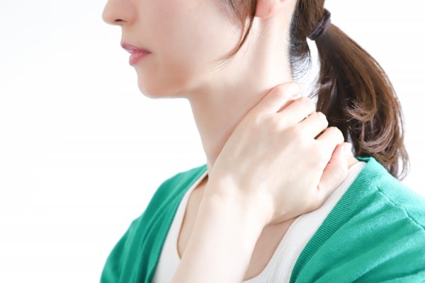 首を押さえている女性