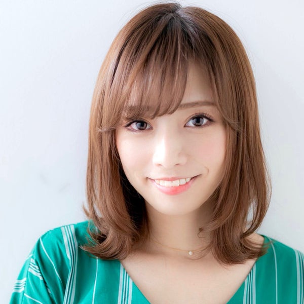 長い伸ばしかけ前髪をふんわり横に流す女性