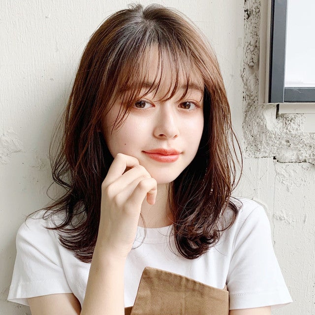 シースルーバング&ゆるふわパーマのミディアムヘアの女性