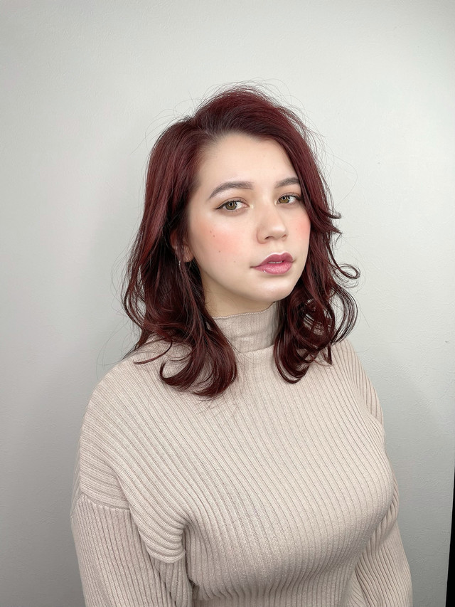 ベージュのセーターを着た赤い髪色の女性