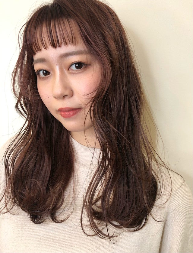 オン眉でぱっつんスタイルのロングヘアの女性