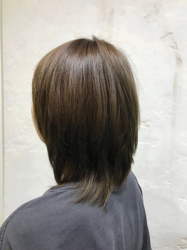 アッシュグリーンカラーのストレートヘアの女性の後ろ姿